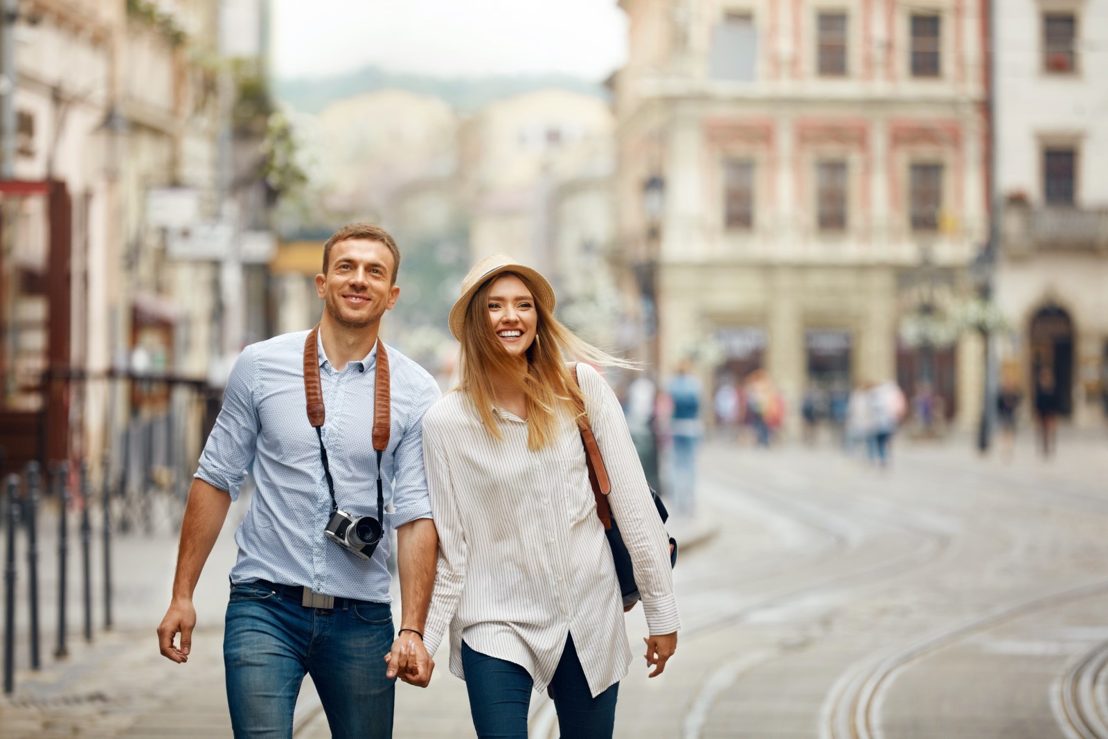 Tourist couple walking down a European city street.