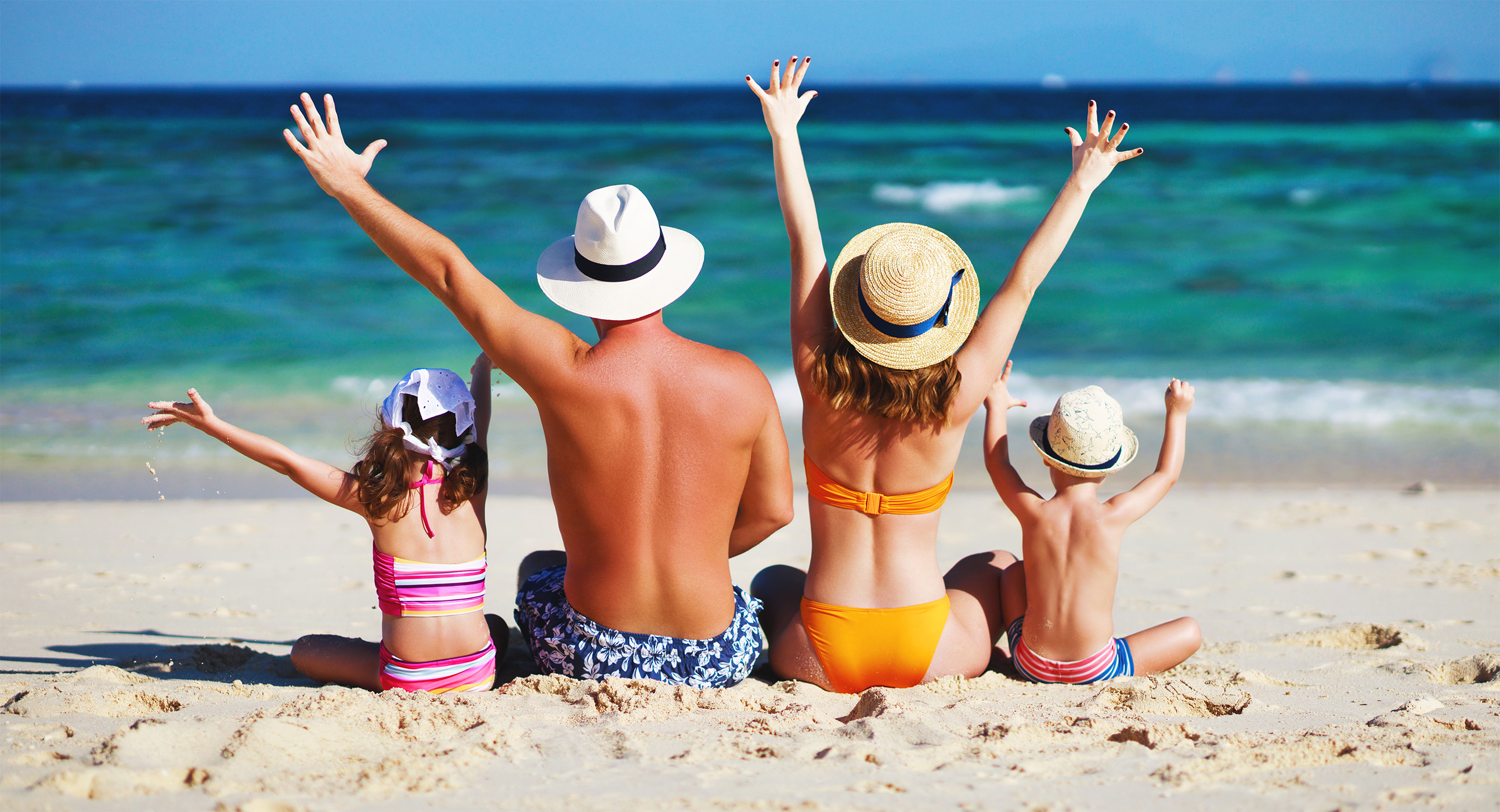 A family enjoys a beach vacation bought with rewards from their Visa Card.