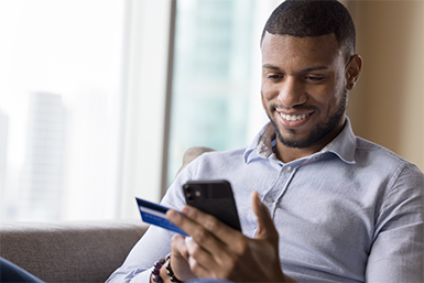 A man mamages his checking account with Mobile Banking.