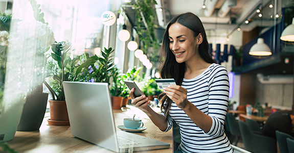 A woman in a restaurant pays for her lunch with a VISA Platinum Credit Card.